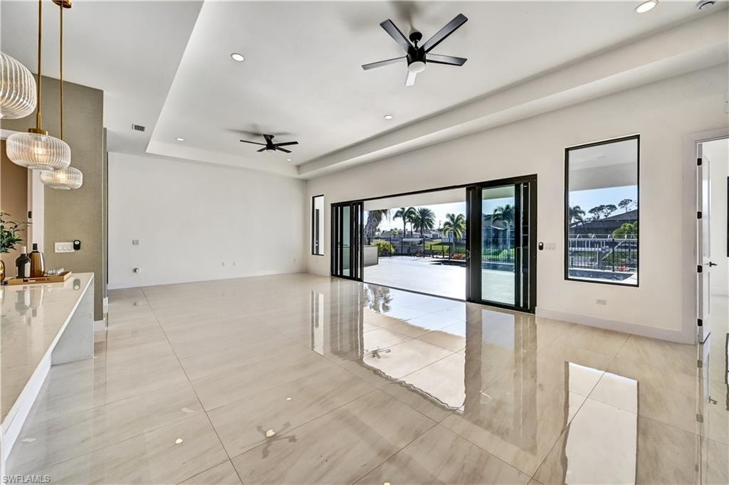 Unfurnished room with recessed lighting, a ceiling fan, a raised ceiling, and light tile patterned floors