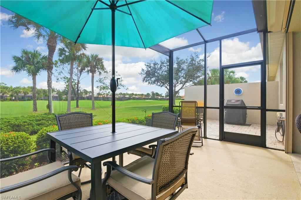 Sunroom featuring view of golf course, outdoor dining space, and a patio