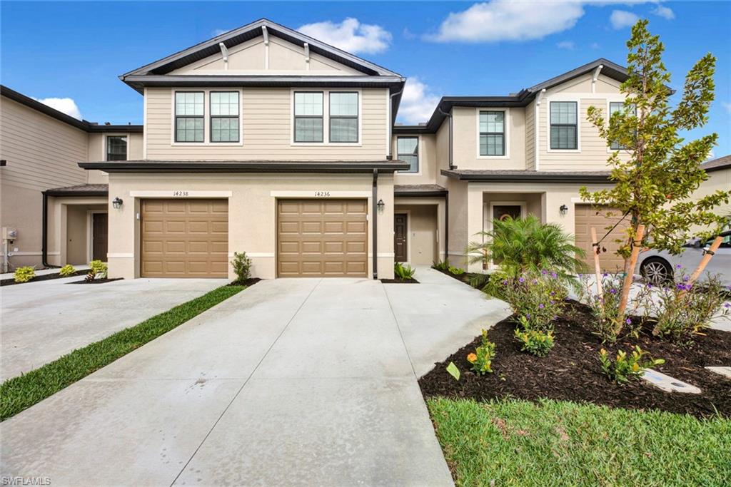 View of front of house with concrete driveway, stucco siding, and a garage