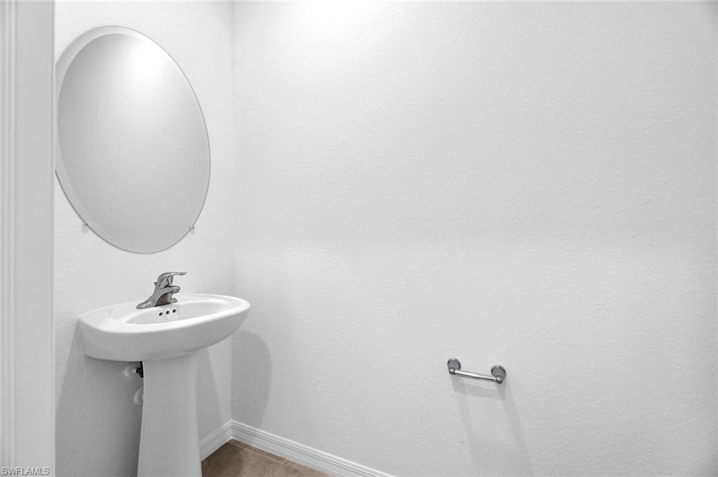 Bathroom with tile patterned floors and a textured wall