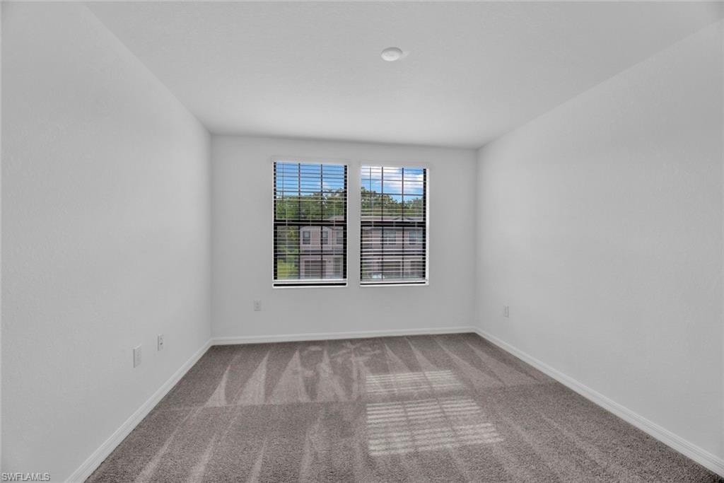 Spare room with light colored carpet and baseboards