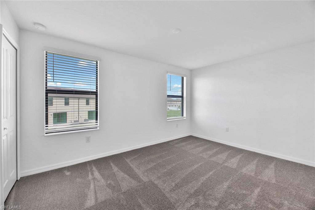 Carpeted empty room featuring baseboards