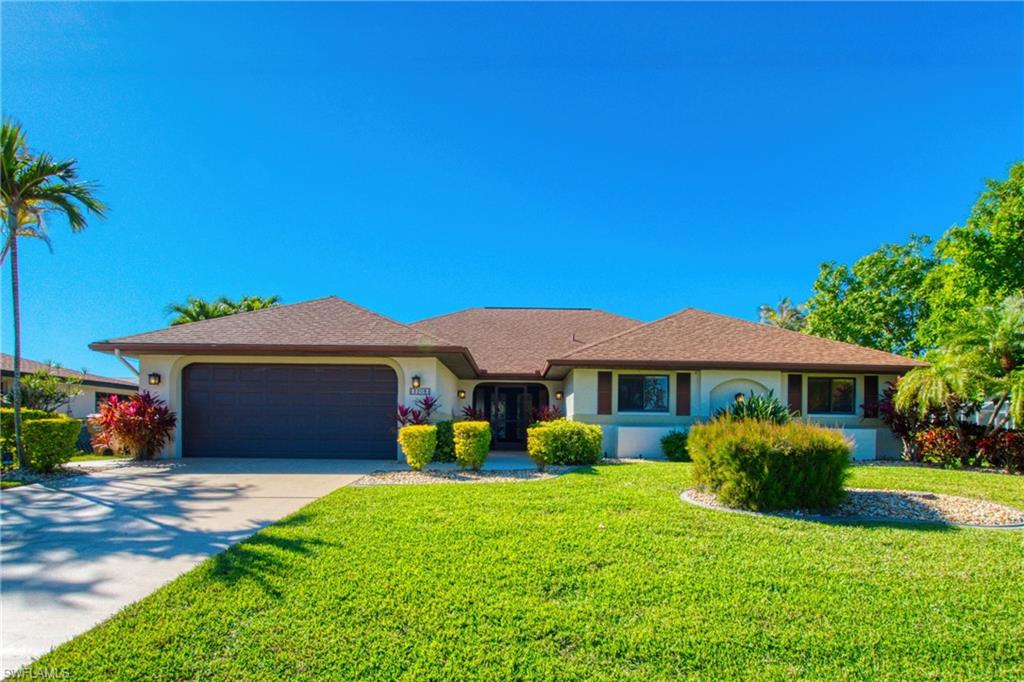 Single story home with concrete driveway, stucco siding, a front yard, an attached garage, and a shingled roof