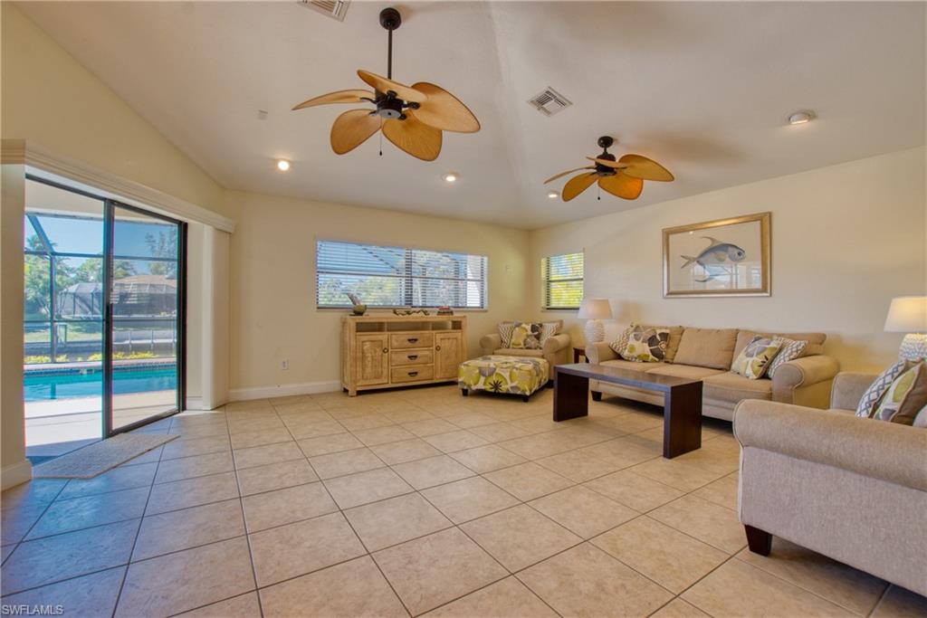 Living area featuring vaulted ceiling, light tile patterned floors, recessed lighting, and ceiling fan