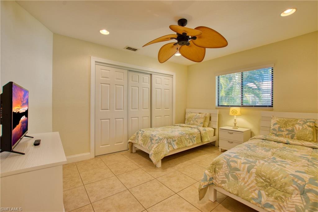Bedroom with recessed lighting, light tile patterned floors, a ceiling fan, and a closet