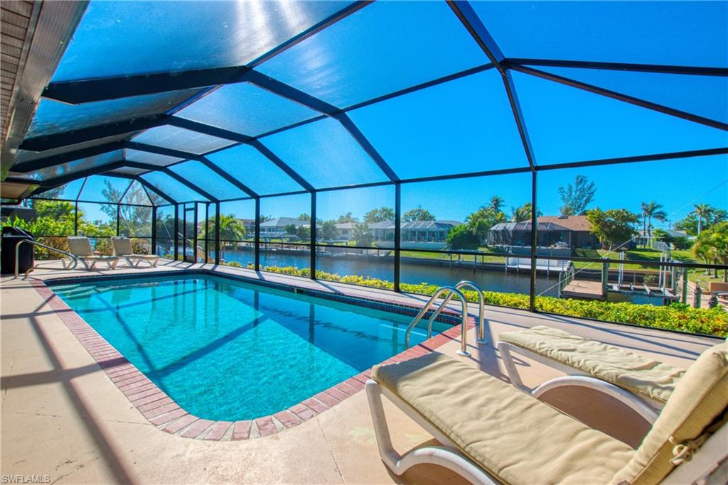 Swimming pool featuring a water view, glass enclosure, a sunroom, a patio, and area for grilling