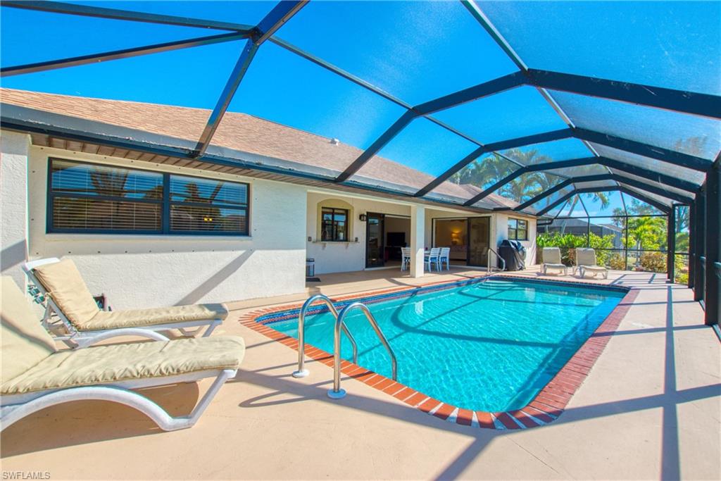 Outdoor pool featuring a patio, a sunroom, a lanai, and a grill