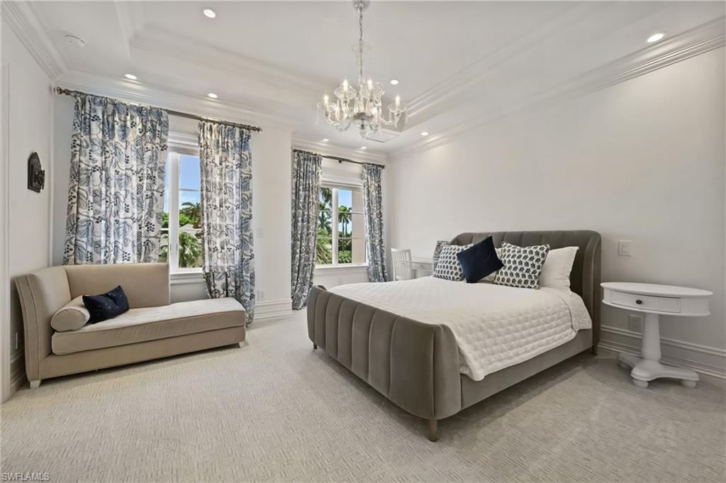 Bedroom featuring a raised ceiling, ornamental molding, a chandelier, carpet flooring, and recessed lighting