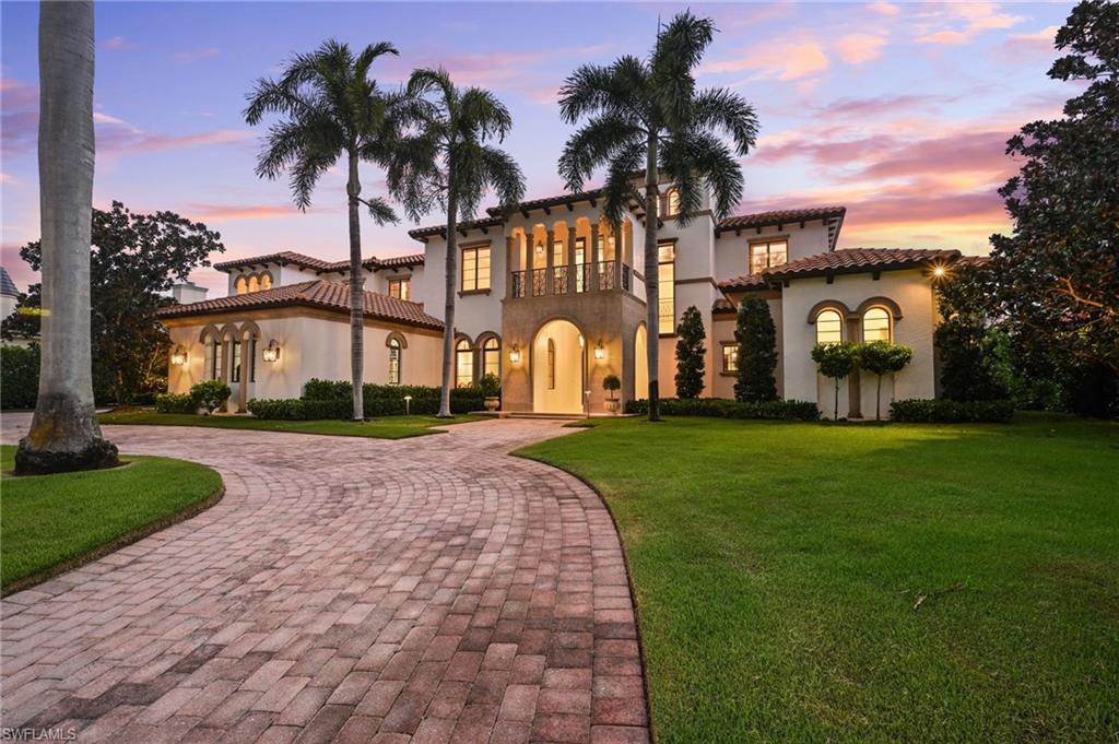 Mediterranean / spanish-style house featuring curved driveway, a balcony, and a yard