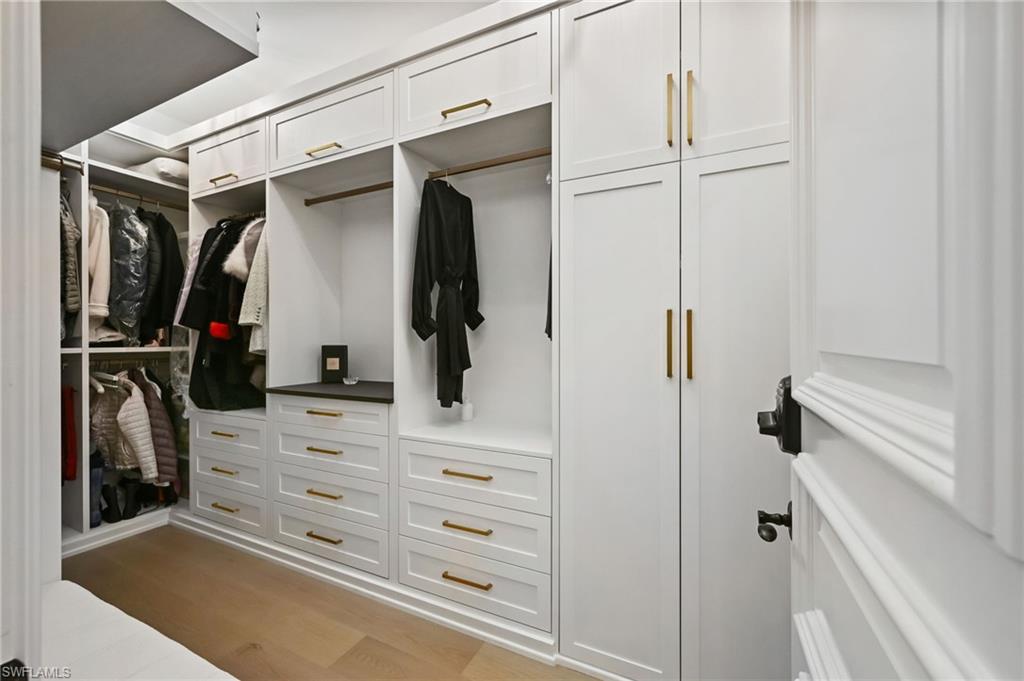 Walk in closet with light wood-type flooring
