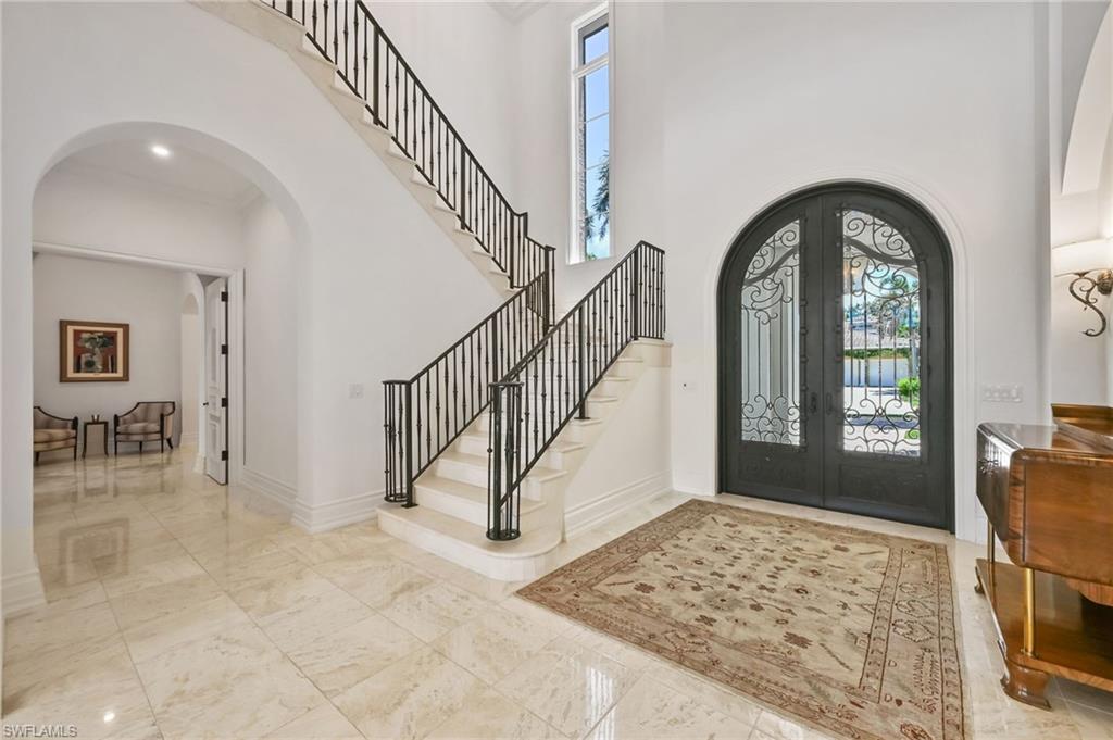 Entrance foyer with arched walkways, plenty of natural light, french doors, and a towering ceiling