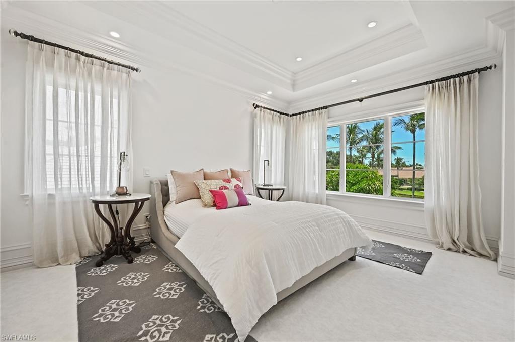 Carpeted bedroom with crown molding, a tray ceiling, and recessed lighting