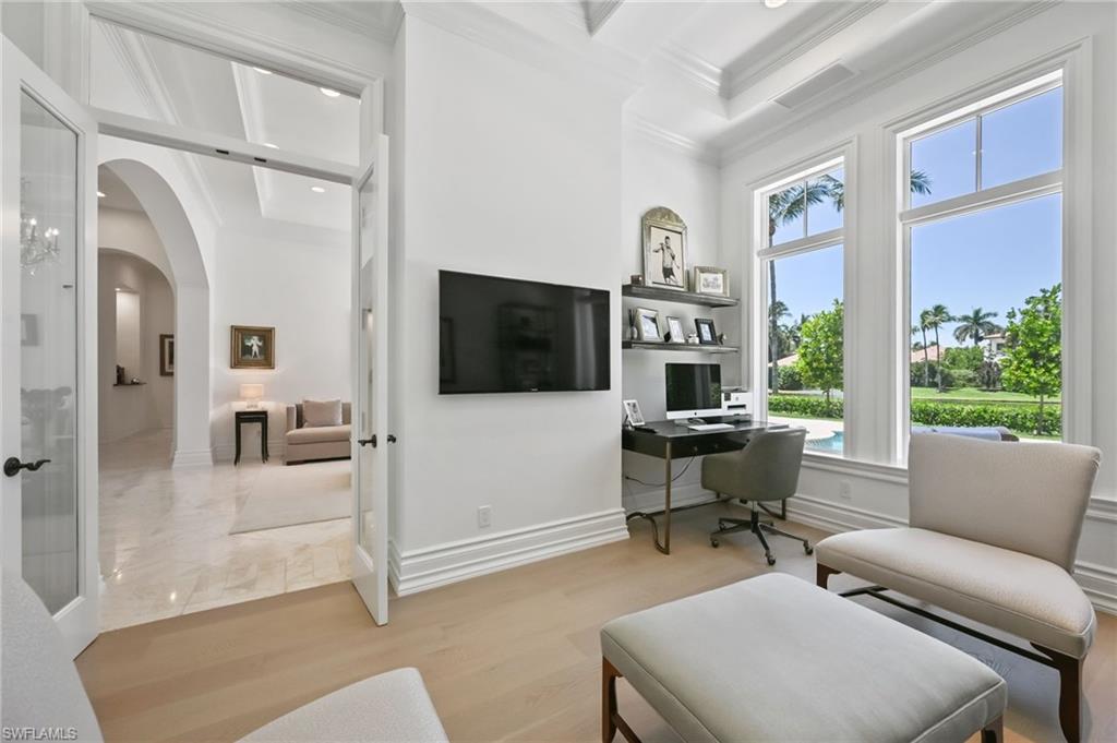 Home office with ornamental molding, light wood-type flooring, arched walkways, and recessed lighting