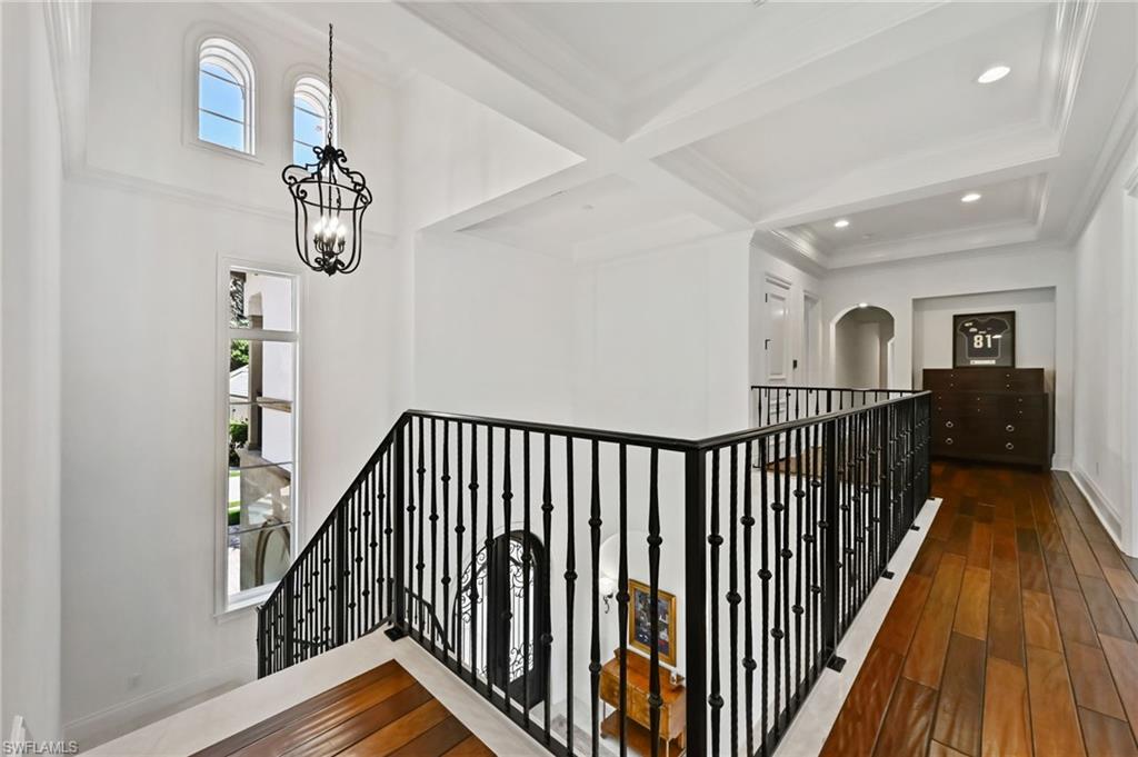 Hallway with coffered ceiling, beam ceiling, dark wood finished floors, and recessed lighting