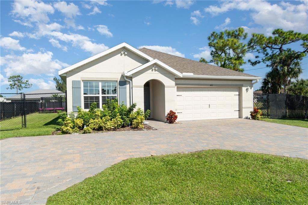 Ranch-style home featuring stucco siding, decorative driveway, and a garage