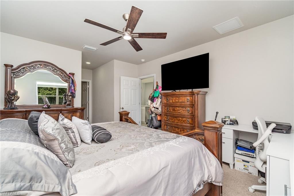 Carpeted bedroom featuring a ceiling fan