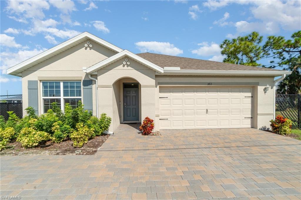 Single story home featuring decorative driveway, a garage, and stucco siding