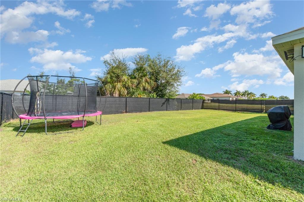 Fenced backyard with a trampoline