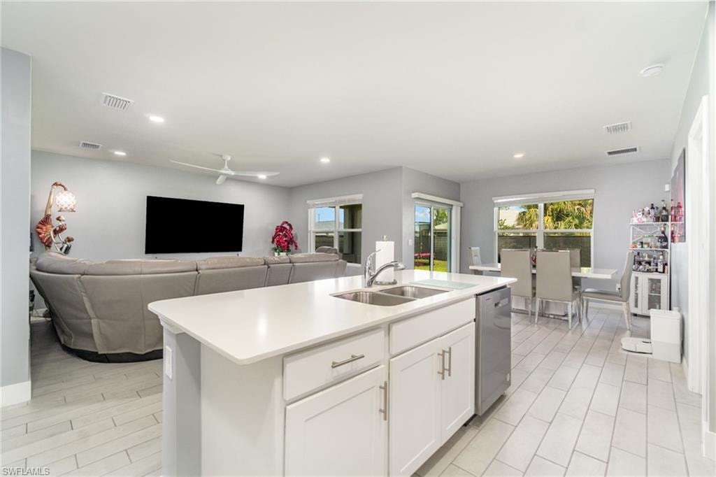 Kitchen featuring white cabinetry, open floor plan, ceiling fan, recessed lighting, and an island with sink