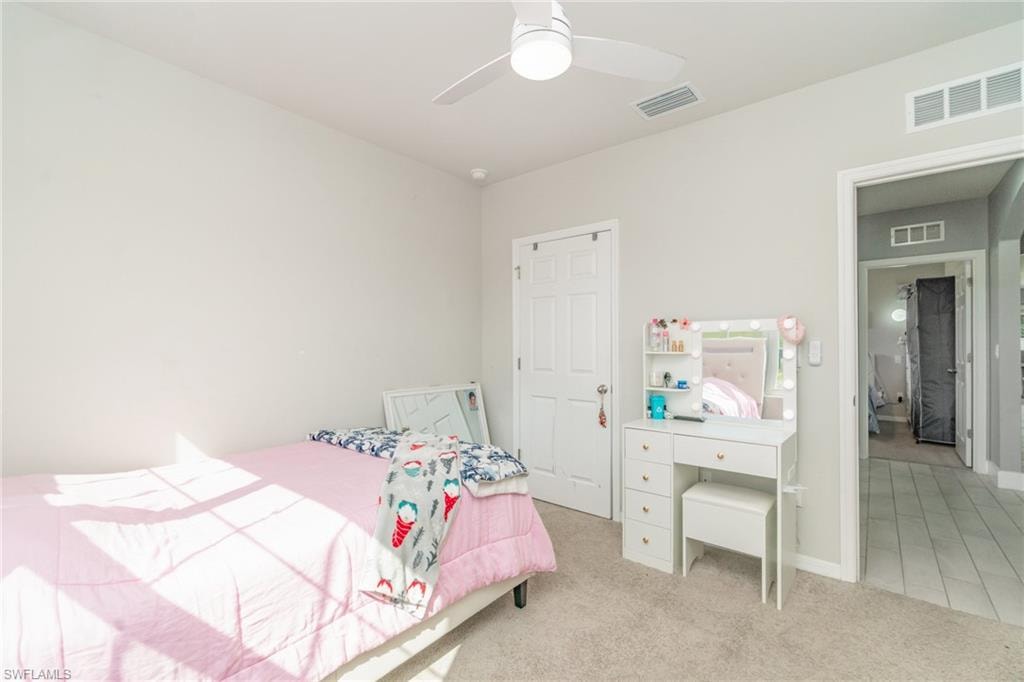 Bedroom featuring light colored carpet and a ceiling fan
