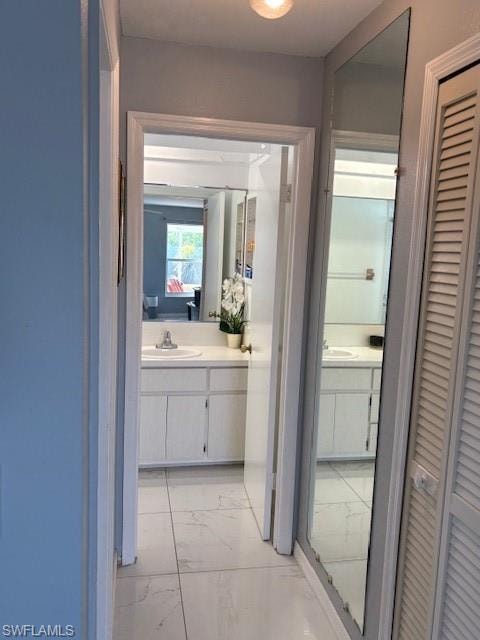 Full bathroom with light marble finish floors, a closet, vanity, and ensuite bath