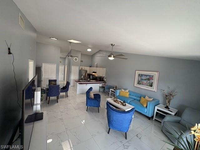 Living area featuring lofted ceiling, a ceiling fan, and light marble finish floors