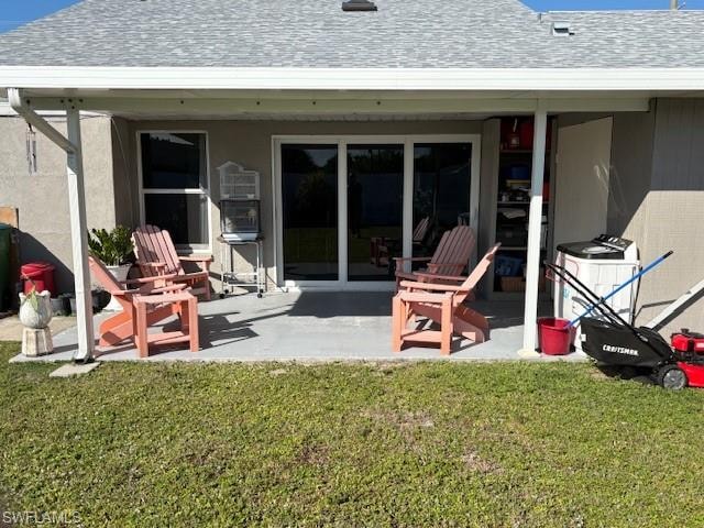 Rear view of house with roof with shingles, a patio area, and a yard