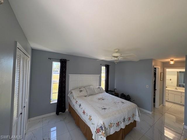Bedroom with a closet, multiple windows, ceiling fan, and light marble finish floors