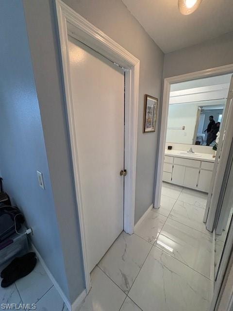 Corridor featuring light marble finish floors and baseboards