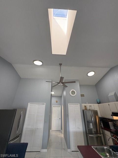 Kitchen featuring refrigerator, stainless steel refrigerator, a skylight, and recessed lighting