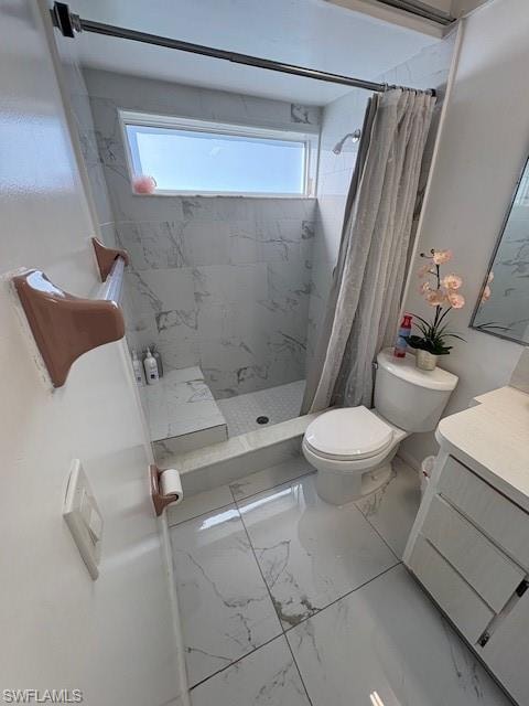 Bathroom with vanity, a marble finish shower, healthy amount of natural light, and marble finish flooring