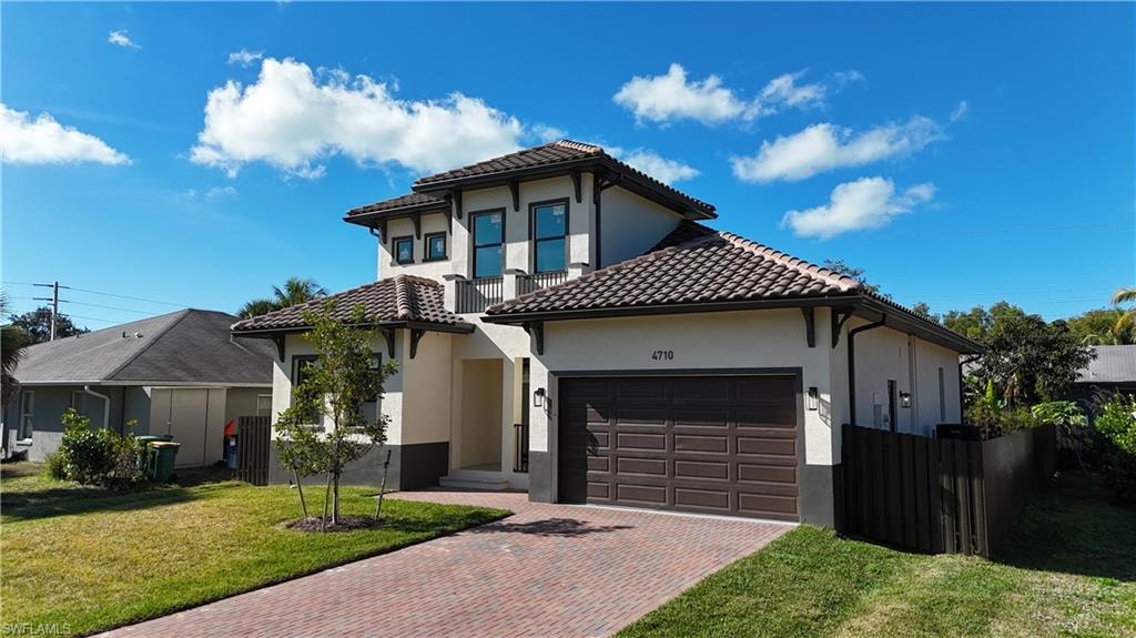 Mediterranean / spanish home featuring decorative driveway, stucco siding, a garage, and a tiled roof