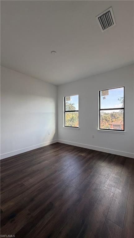 Unfurnished room featuring dark wood-type flooring and baseboards