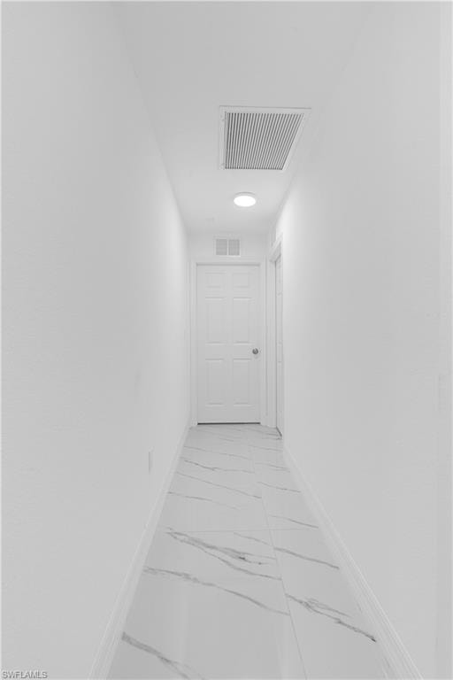 Hall with light marble finish floors and baseboards