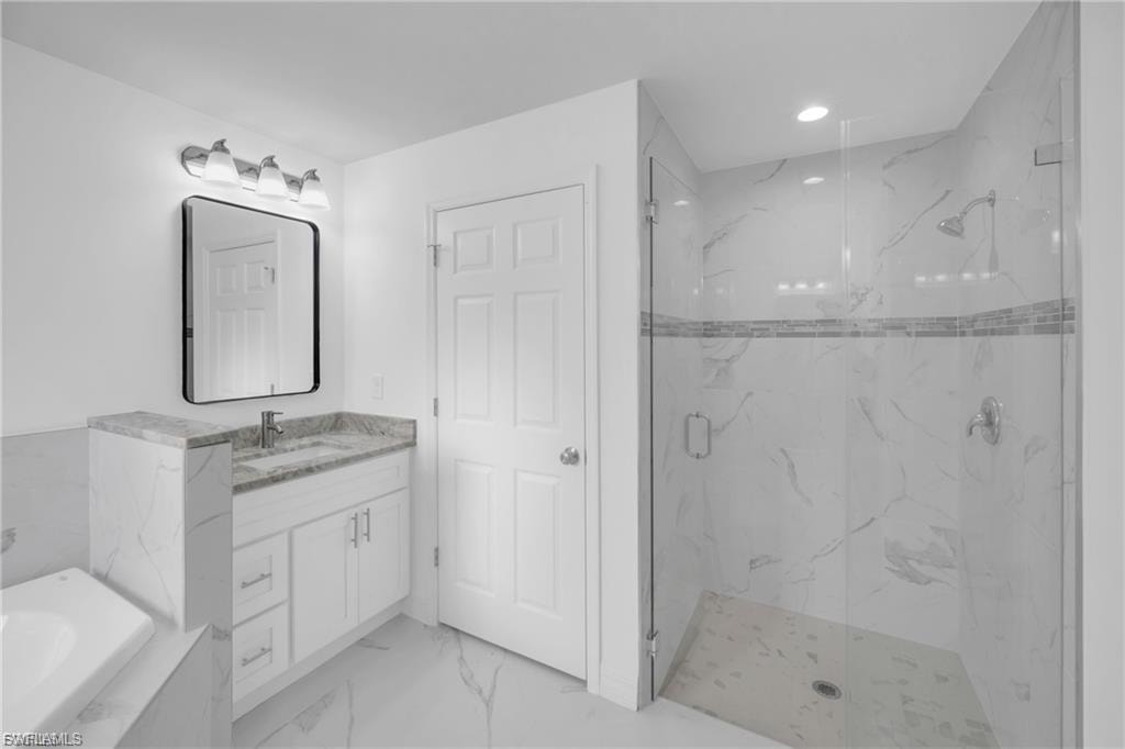 Bathroom featuring a marble finish shower, vanity, light marble finish flooring, recessed lighting, and a tub