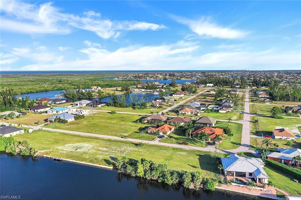 Aerial perspective of suburban area featuring a nearby body of water