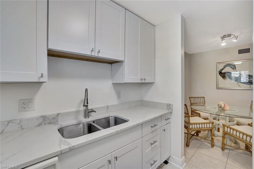 Living area with light tile patterned floors and baseboards