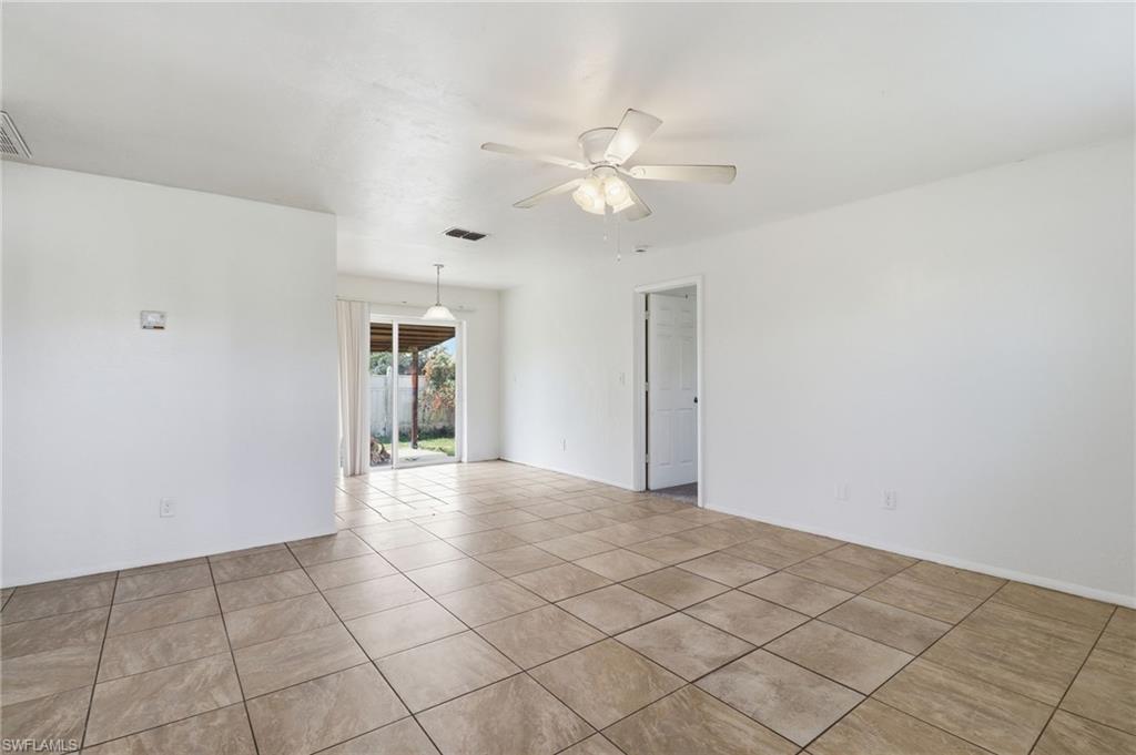 Empty room with light tile patterned floors and a ceiling fan