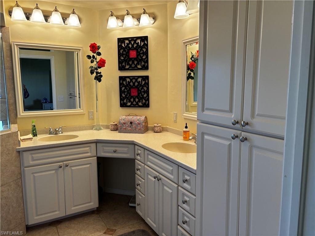 Full bathroom with double vanity and dark tile patterned flooring