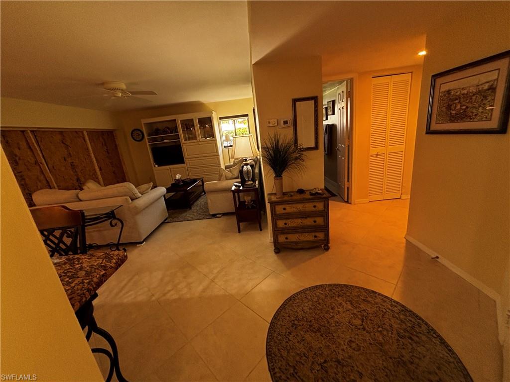 Living area with a ceiling fan and light tile patterned floors