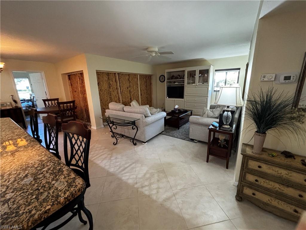 Living room featuring a ceiling fan and light tile patterned floors