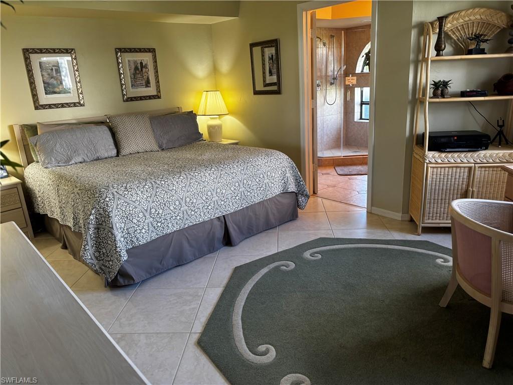 Bedroom with light tile patterned floors and ensuite bath