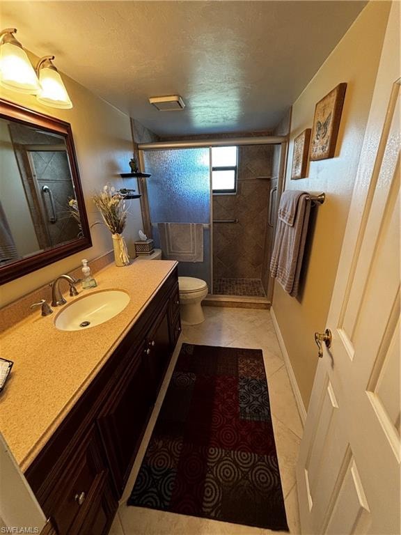 Full bathroom featuring vanity, light tile patterned floors, a shower stall, and a textured ceiling