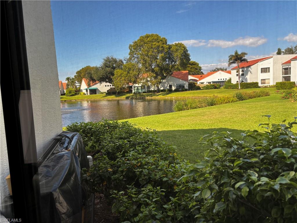 View of grassy yard with a residential view and a water view