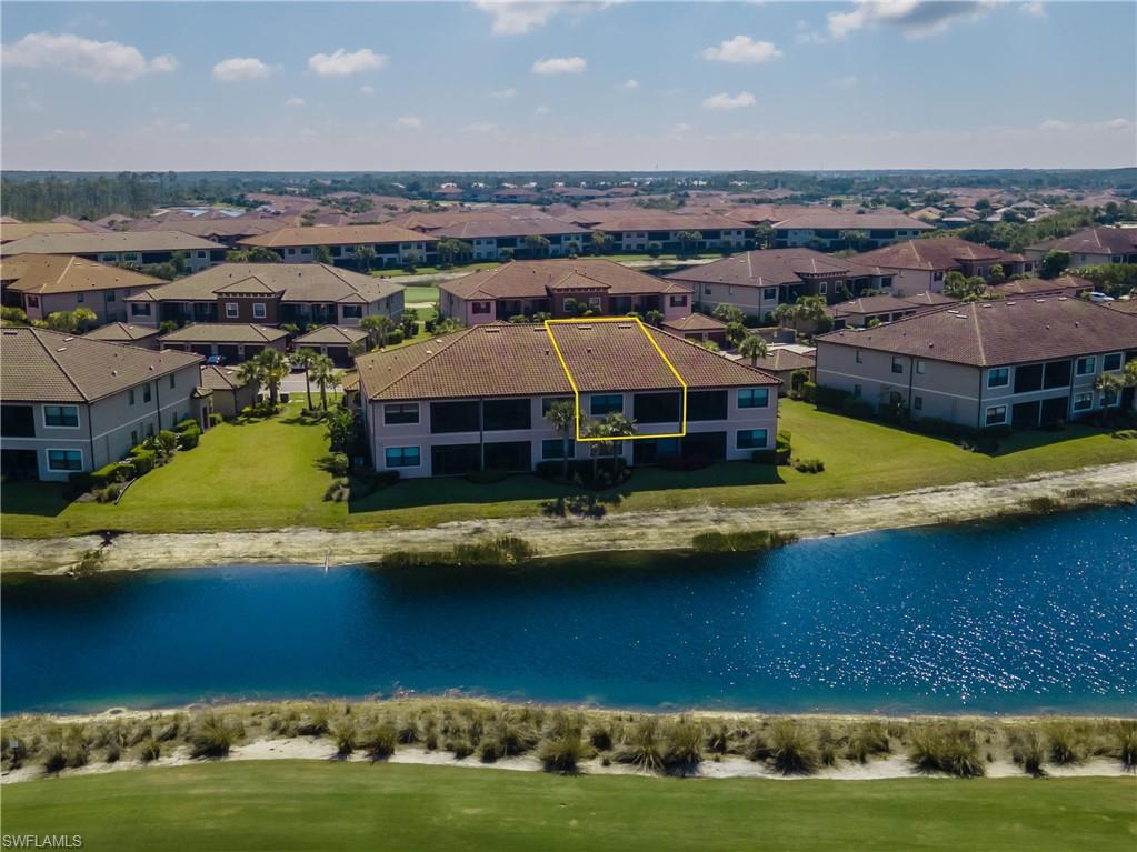 Aerial perspective of suburban area with a nearby body of water and property boundaries highlighted