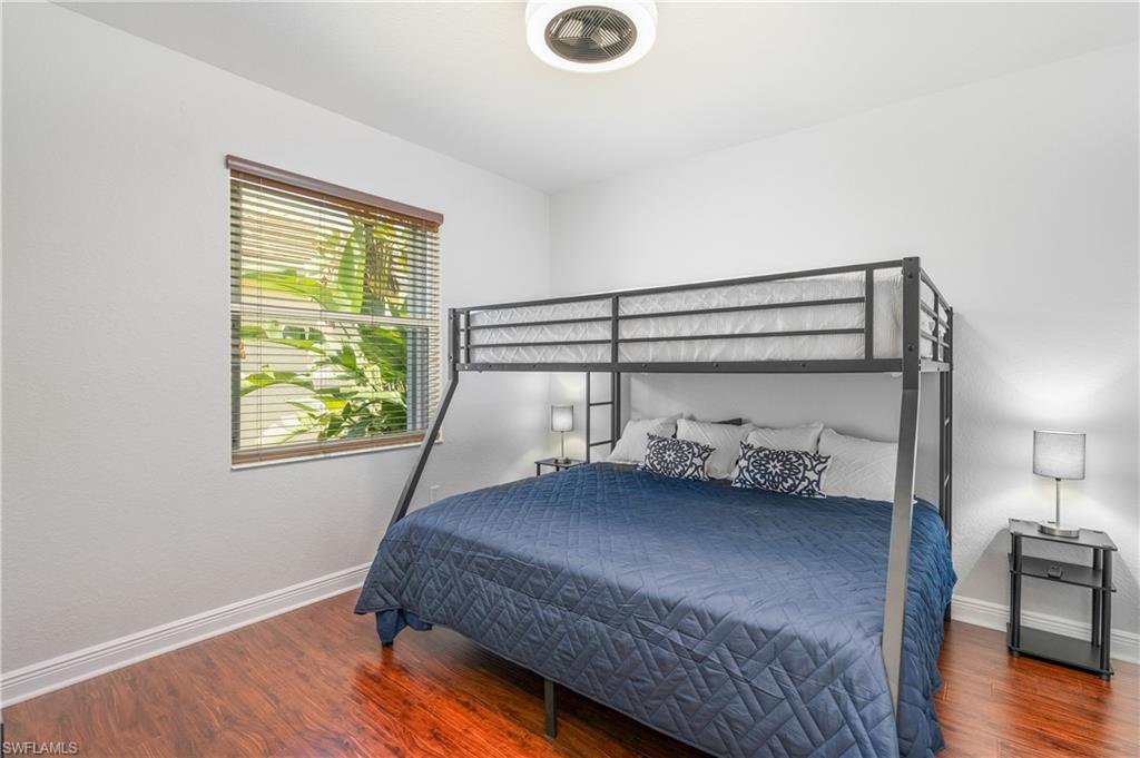 Bedroom with dark wood-type flooring and baseboards