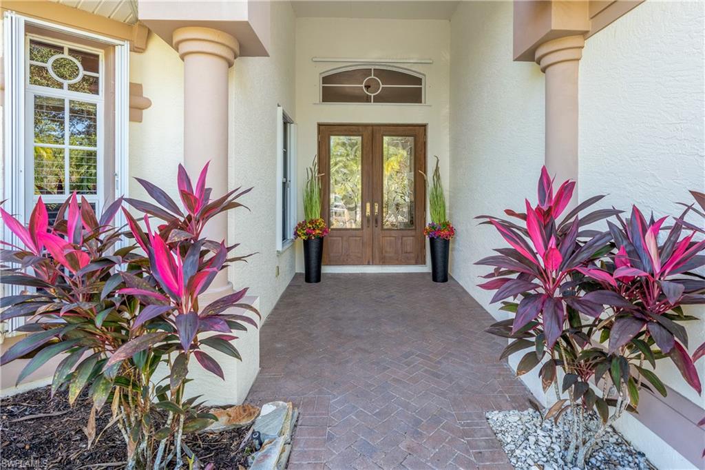 Doorway to property featuring french doors, stucco siding, and covered porch
