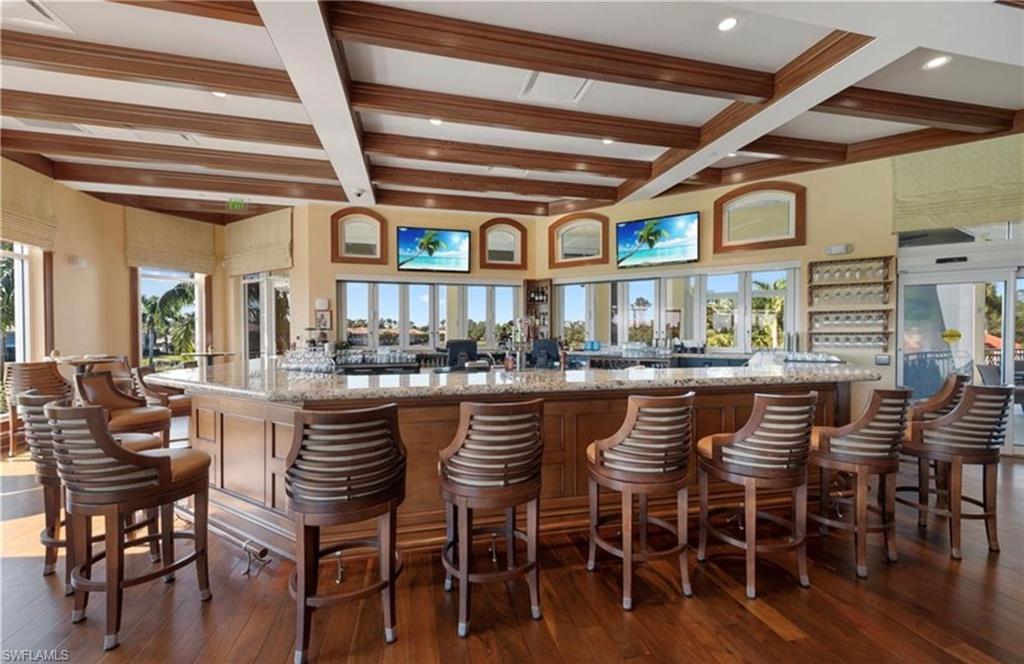 Bar featuring light stone counters, beamed ceiling, coffered ceiling, and recessed lighting