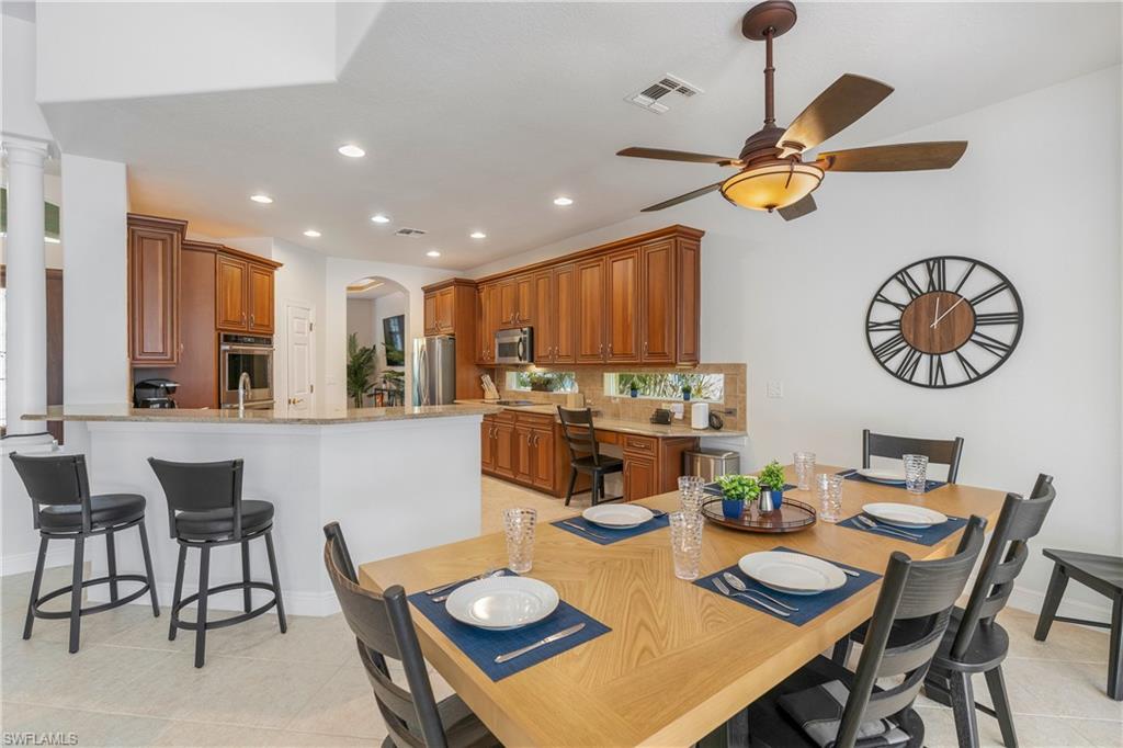 Dining space featuring light tile patterned floors, recessed lighting, arched walkways, and ceiling fan