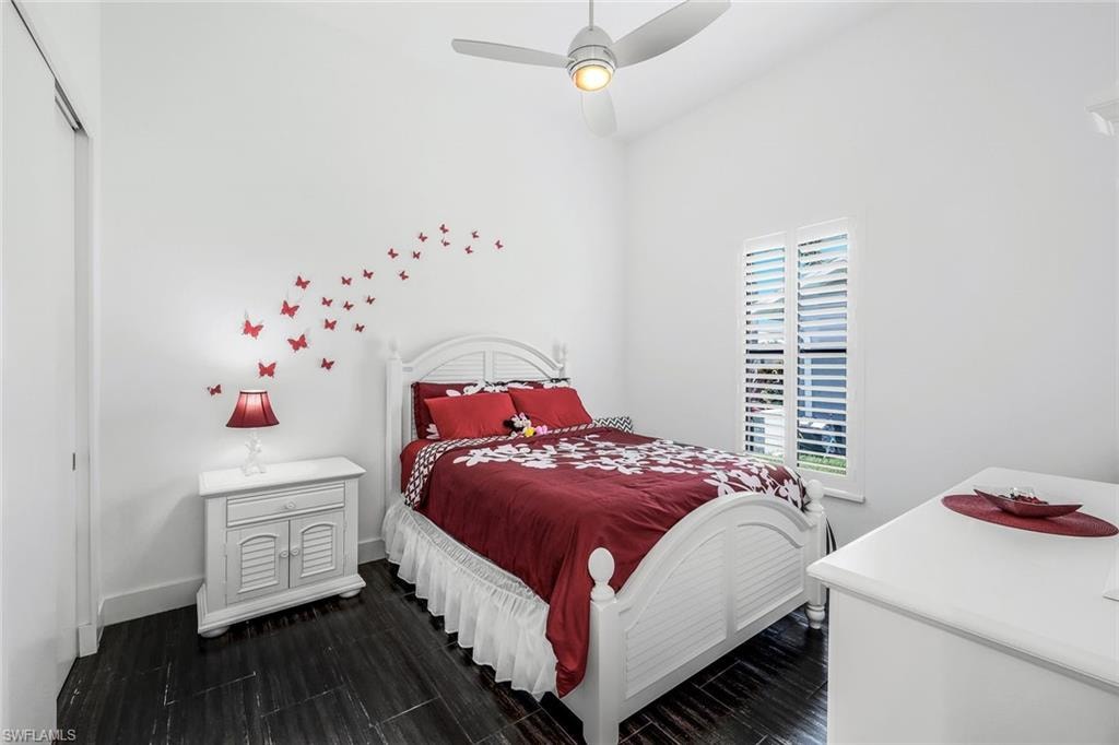 Bedroom featuring a ceiling fan, dark wood-type flooring, and a closet